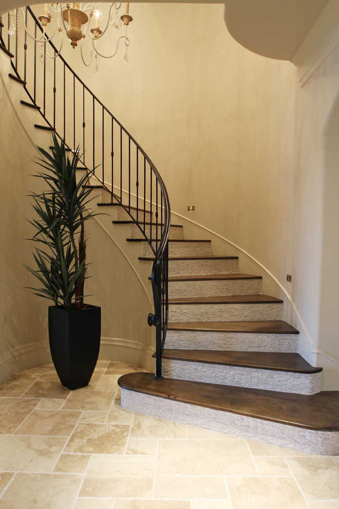 This is an example of a large traditional curved staircase in Houston.