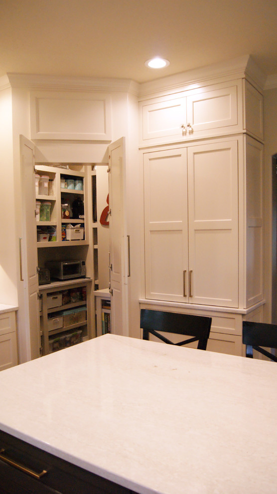 Example of a transitional kitchen design with flat-panel cabinets, white cabinets, quartz countertops, gray backsplash and white countertops