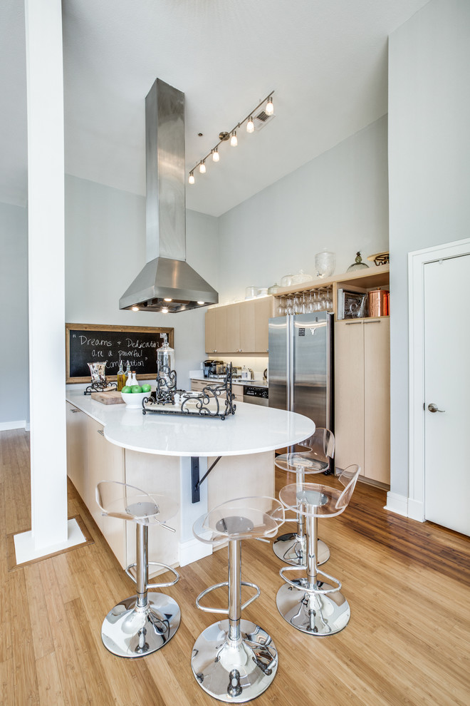Inspiration for a small transitional single-wall open plan kitchen in Dallas with an undermount sink, flat-panel cabinets, light wood cabinets, quartz benchtops, white splashback, stainless steel appliances, light hardwood floors and with island.