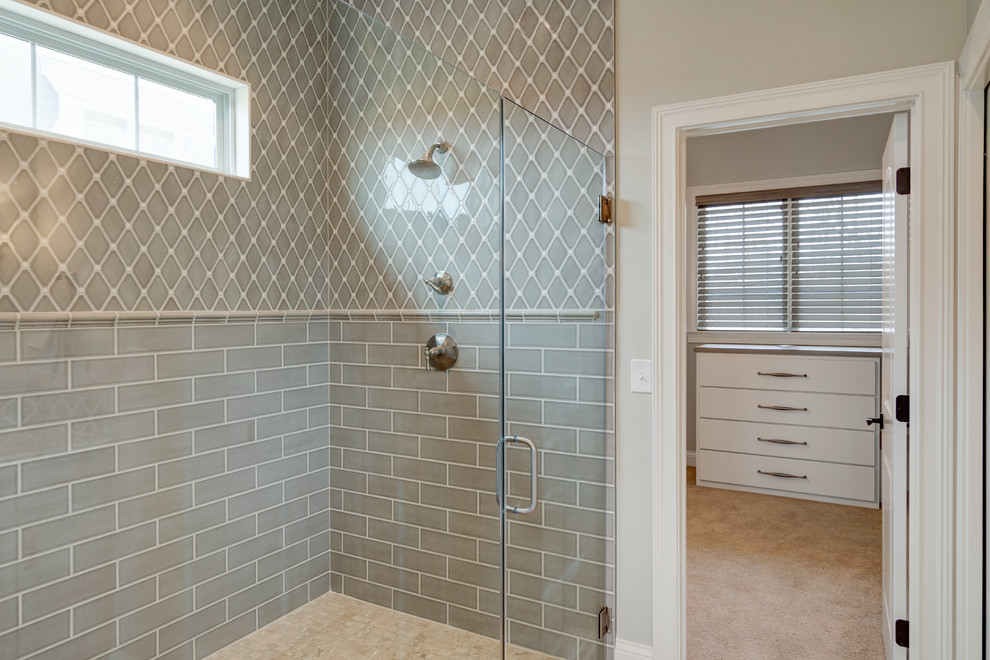 Large traditional master bathroom in Indianapolis with recessed-panel cabinets, grey cabinets, a corner shower, gray tile, ceramic tile, beige walls, travertine floors, an undermount sink, granite benchtops, beige floor and a hinged shower door.