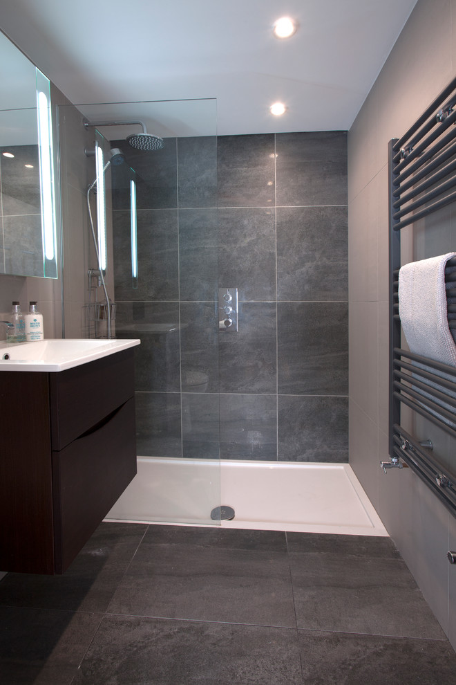 Small contemporary 3/4 bathroom in London with flat-panel cabinets, grey cabinets, an open shower, gray tile, ceramic tile and a drop-in sink.