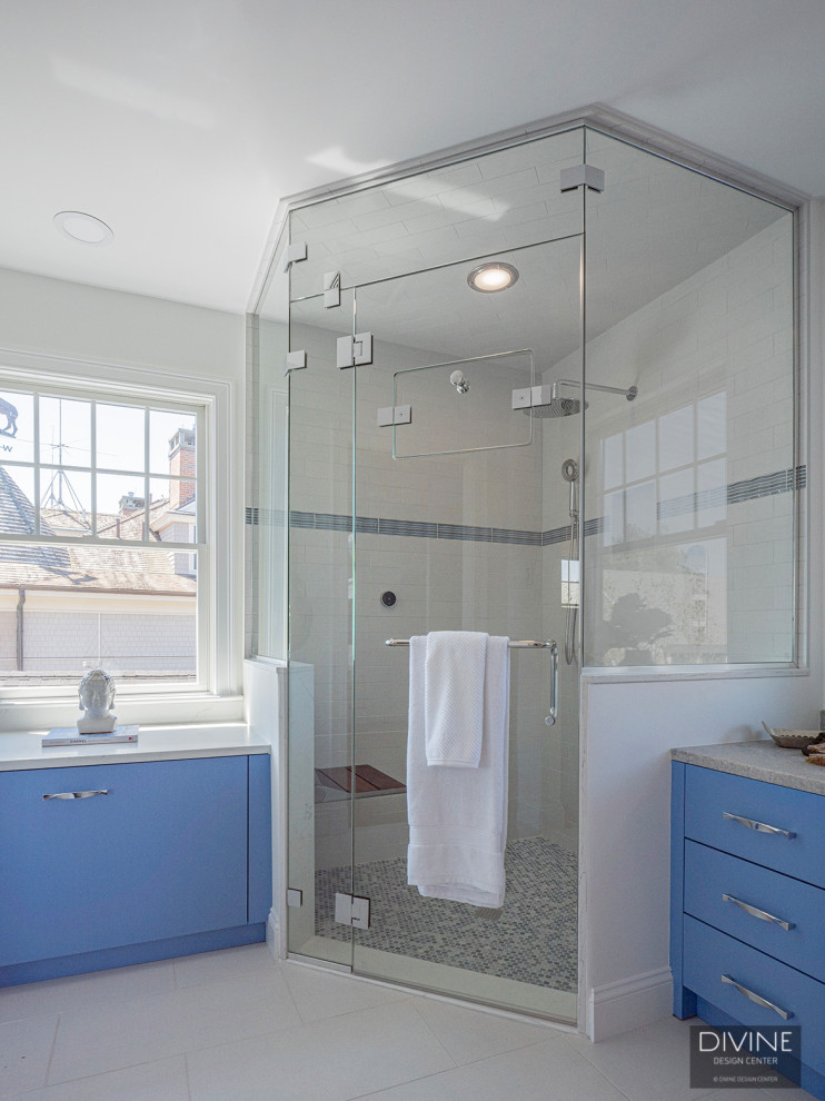Photo of an expansive traditional bathroom in Boston with glass-front cabinets, blue cabinets, a freestanding bath, a corner shower, blue tiles, blue walls, ceramic flooring, white floors, a hinged door, a shower bench and double sinks.