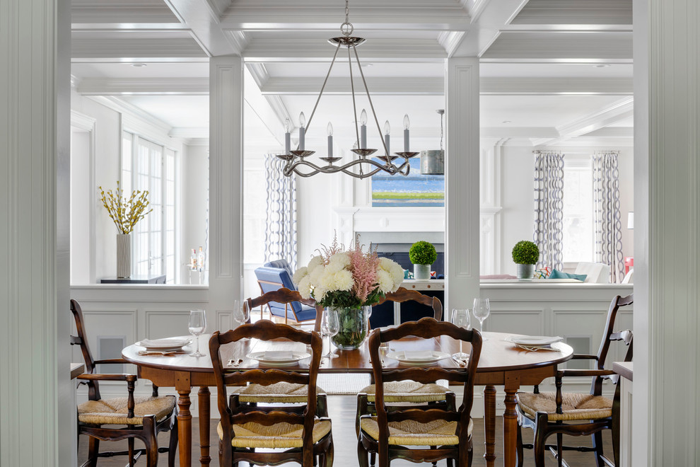 This is an example of a traditional dining room in Boston with white walls and dark hardwood floors.