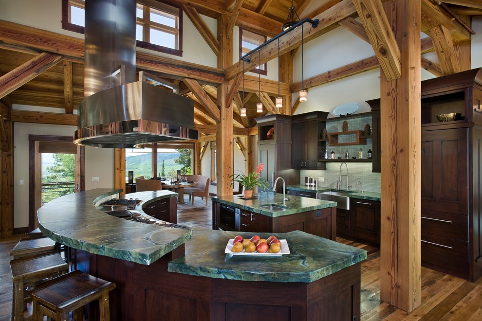 Design ideas for a large country galley open plan kitchen in Denver with a farmhouse sink, shaker cabinets, dark wood cabinets, granite benchtops, green splashback, panelled appliances, medium hardwood floors and multiple islands.