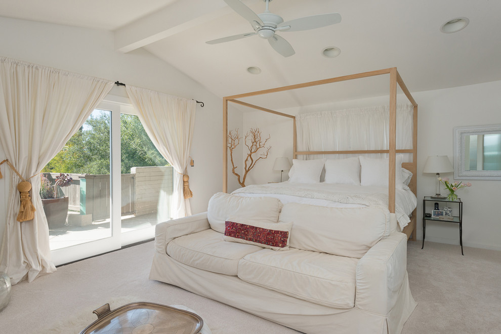 This is an example of a contemporary master bedroom in Los Angeles with white walls, carpet and no fireplace.