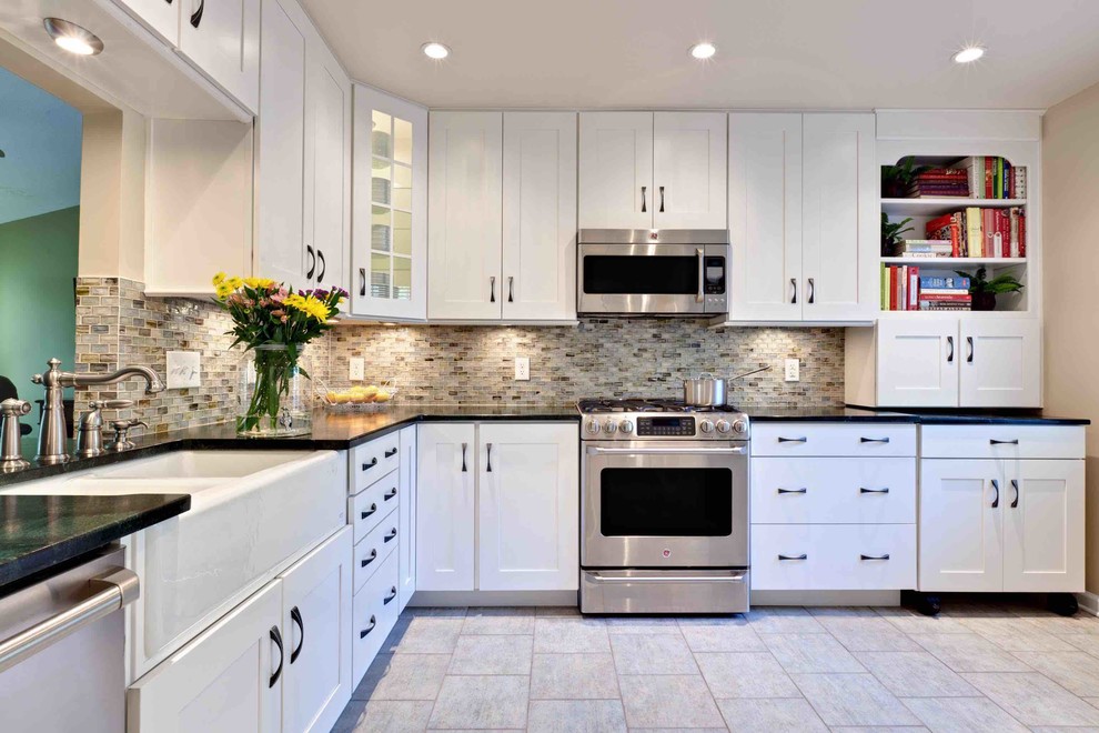 This is an example of a small transitional u-shaped eat-in kitchen in Atlanta with a farmhouse sink, recessed-panel cabinets, white cabinets, soapstone benchtops, multi-coloured splashback, glass tile splashback, stainless steel appliances, porcelain floors, with island, beige floor and green benchtop.