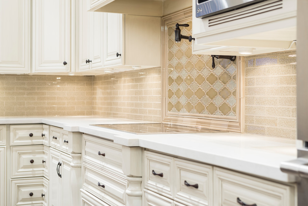 Example of a large transitional l-shaped medium tone wood floor and brown floor eat-in kitchen design in Phoenix with raised-panel cabinets, beige cabinets, quartz countertops, beige backsplash, glass tile backsplash, stainless steel appliances, an island and an undermount sink