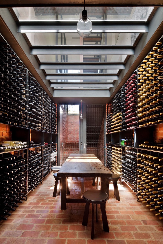 Photo of a contemporary wine cellar in Melbourne with brick floors and storage racks.