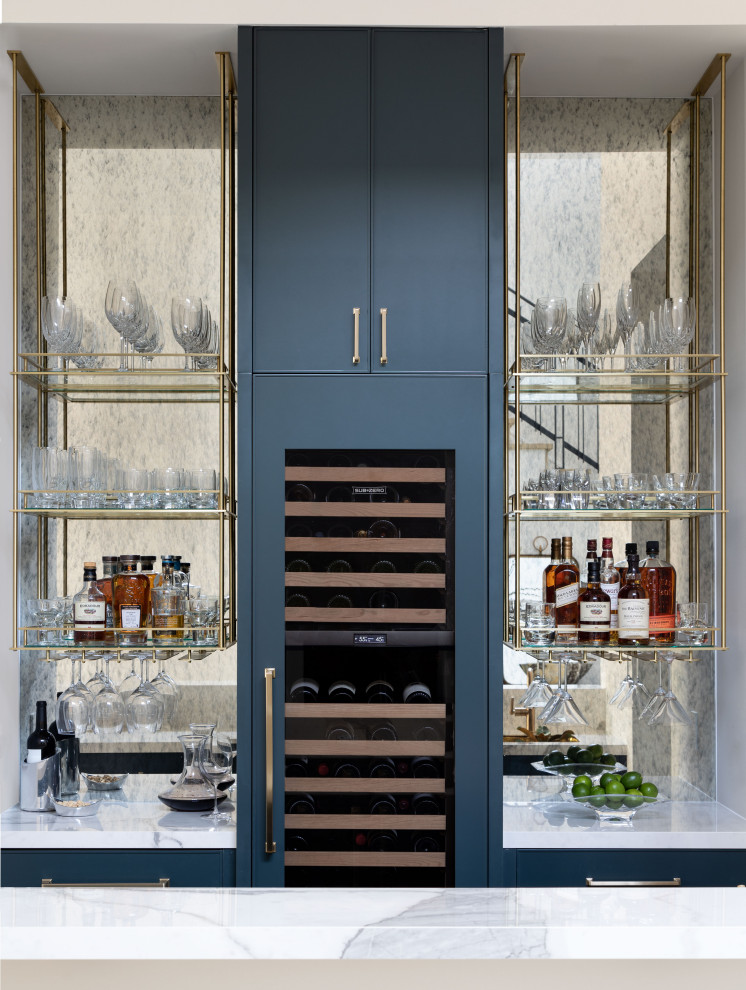 Design ideas for a small transitional single-wall wet bar in Houston with blue cabinets, mirror splashback and white benchtop.