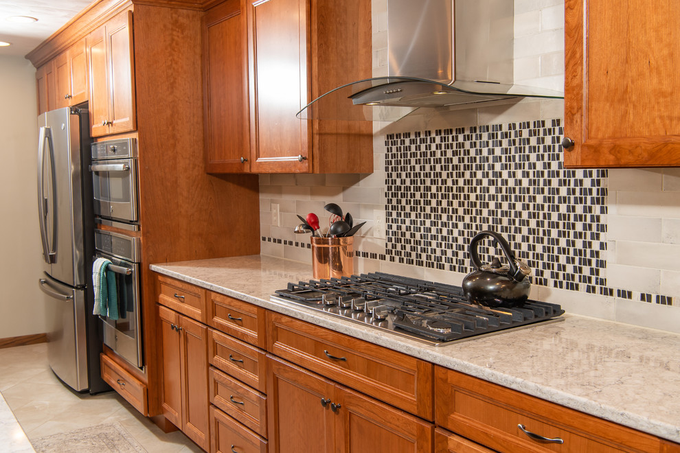 Example of a huge transitional l-shaped porcelain tile and white floor eat-in kitchen design with an undermount sink, flat-panel cabinets, medium tone wood cabinets, quartz countertops, white backsplash, ceramic backsplash, stainless steel appliances, two islands and white countertops