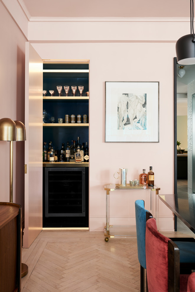 This is an example of a small contemporary single-wall bar cart in New York with black cabinets, black splashback, light hardwood floors and beige floor.