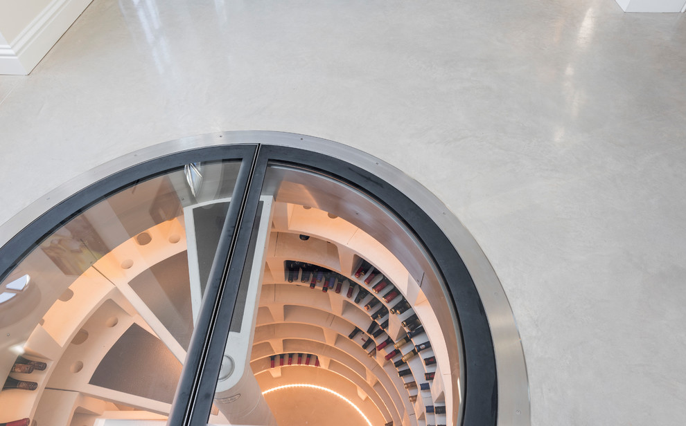 Photo of a mid-sized contemporary wine cellar in London with concrete floors and beige floor.