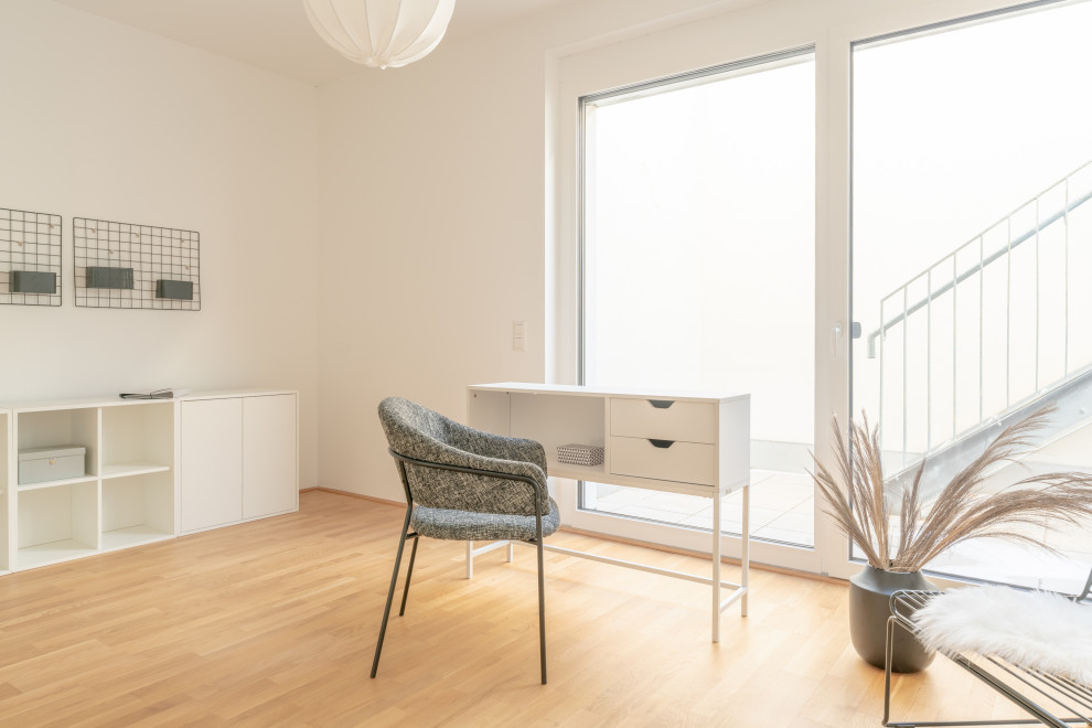 Idée de décoration pour un très grand bureau minimaliste avec un mur blanc, parquet clair, un bureau indépendant, un sol marron et différents habillages de murs.