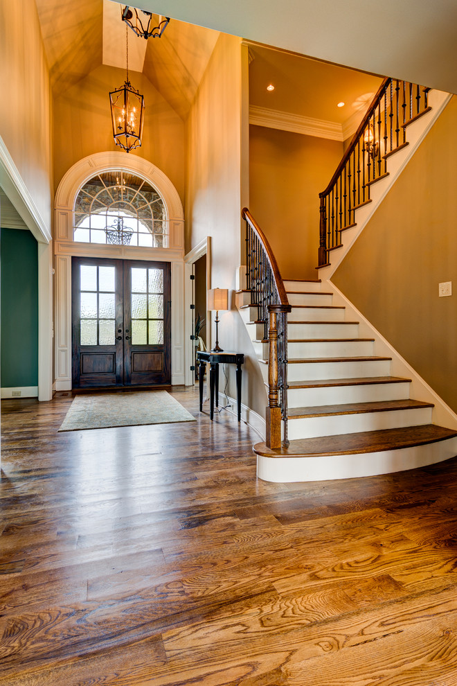 This is an example of a large foyer in Other with beige walls, medium hardwood floors, a double front door and a dark wood front door.