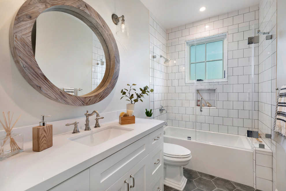 Country 3/4 bathroom in Los Angeles with shaker cabinets, white cabinets, an alcove tub, a shower/bathtub combo, white tile, beige walls, an undermount sink, grey floor, a hinged shower door and white benchtops.