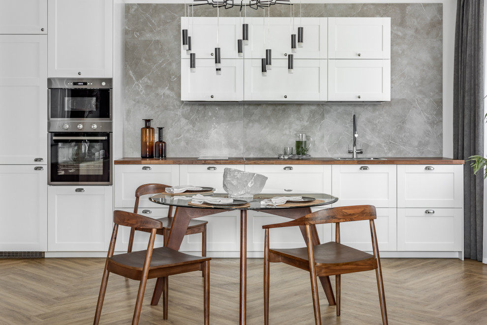 Inspiration for a contemporary single-wall kitchen in Other with a drop-in sink, shaker cabinets, white cabinets, grey splashback, stainless steel appliances, no island, brown floor and brown benchtop.