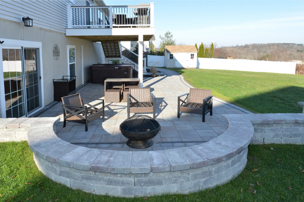 This is an example of a large contemporary back ground level mixed railing terrace in New York with a fire feature and no cover.