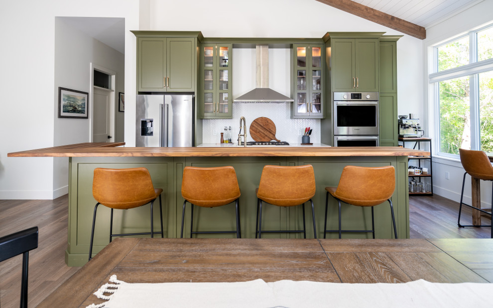 Eat-in kitchen - mid-sized transitional l-shaped medium tone wood floor, brown floor and shiplap ceiling eat-in kitchen idea with an undermount sink, shaker cabinets, green cabinets, quartz countertops, white backsplash, cement tile backsplash, stainless steel appliances, an island and white countertops