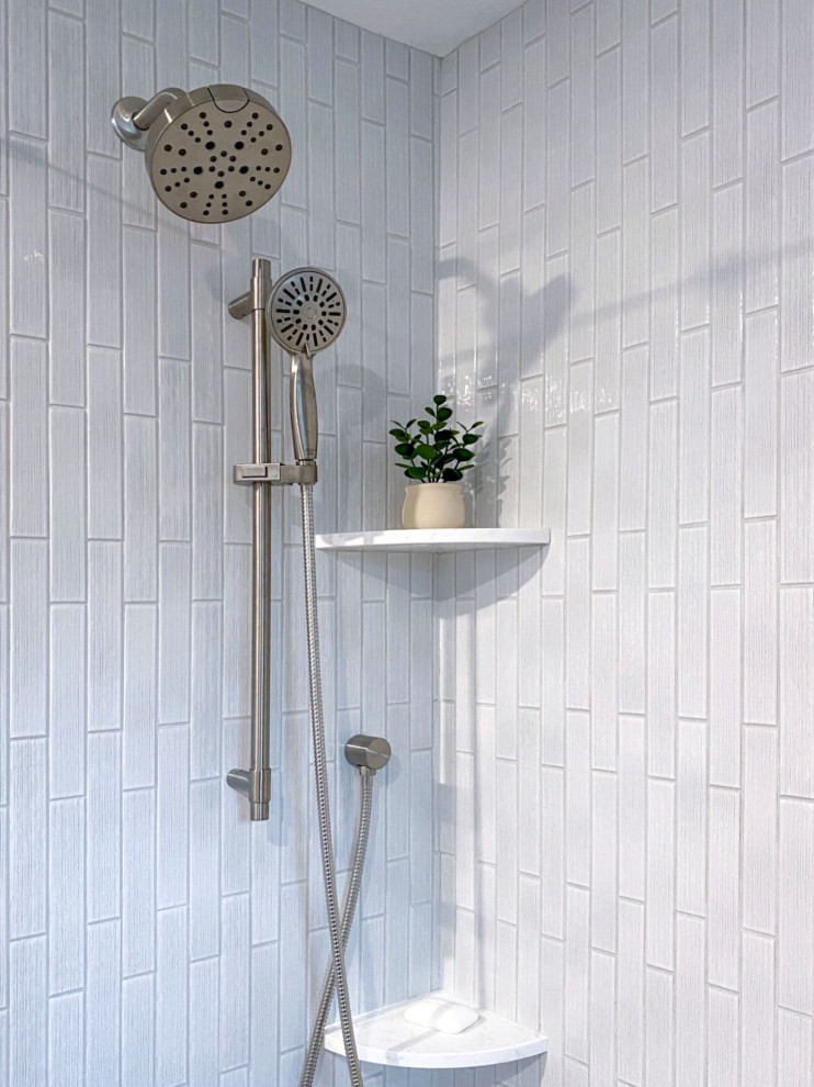 Example of a transitional white tile and ceramic tile porcelain tile, gray floor and single-sink corner shower design in Boston with shaker cabinets, gray cabinets, a one-piece toilet, gray walls, an undermount sink, quartz countertops, a hinged shower door, white countertops and a built-in vanity