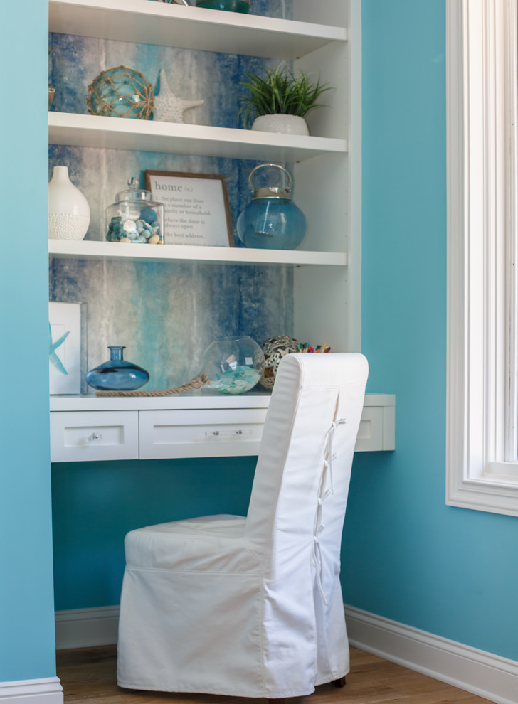 This is an example of a beach style guest bedroom in Jacksonville with blue walls and medium hardwood floors.