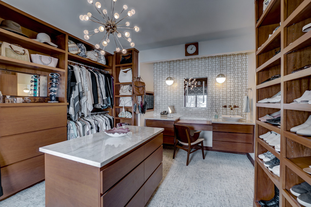 Large midcentury gender-neutral walk-in wardrobe in Minneapolis with flat-panel cabinets, medium wood cabinets, carpet and grey floor.