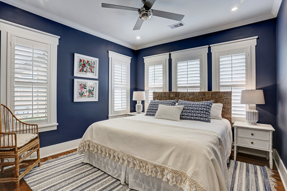 Photo of a transitional guest bedroom in Houston with blue walls, medium hardwood floors and brown floor.