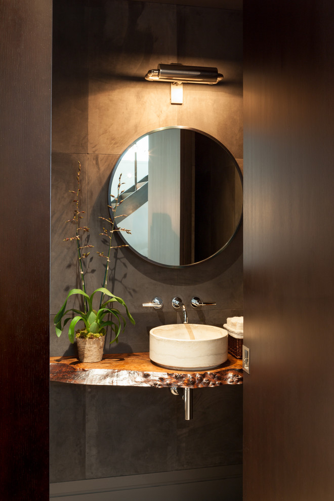 This is an example of a small modern 3/4 bathroom in San Francisco with a vessel sink, furniture-like cabinets, black cabinets, cement tile, grey walls, light hardwood floors and copper benchtops.