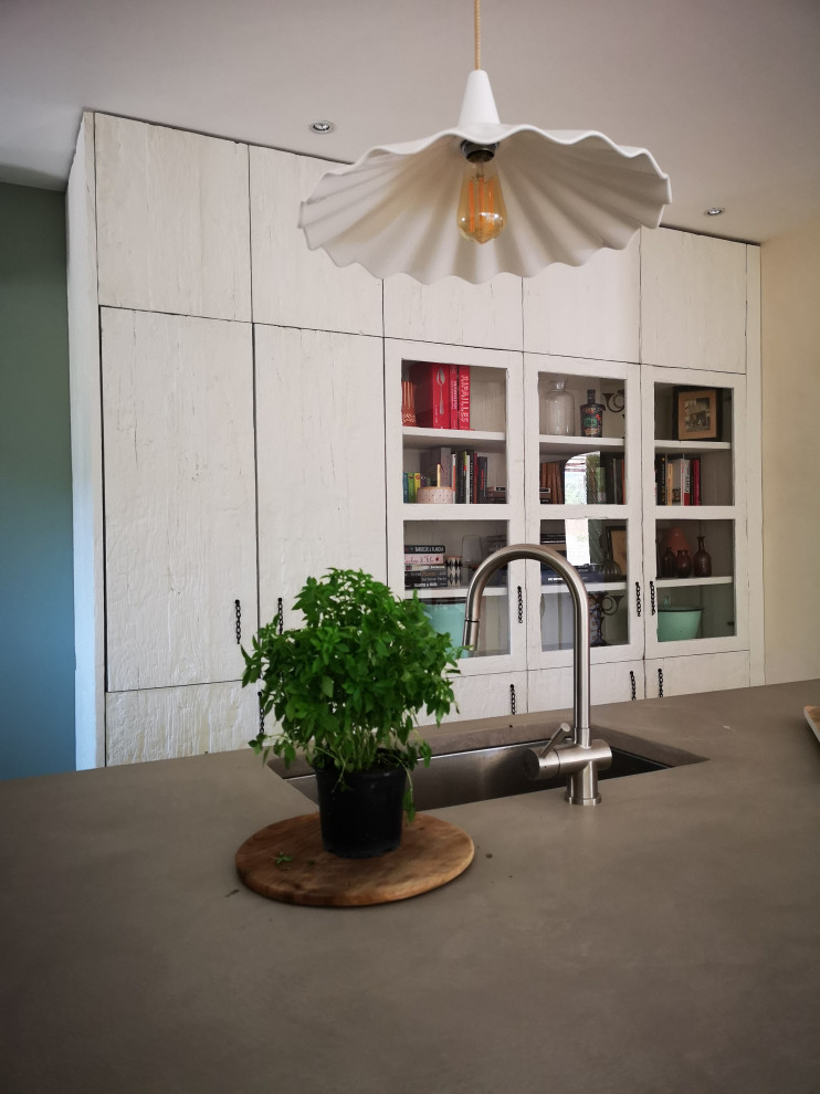 Photo of a mid-sized country u-shaped eat-in kitchen in Other with an undermount sink, beaded inset cabinets, white cabinets, concrete benchtops, green splashback, ceramic splashback, coloured appliances, concrete floors, multiple islands, grey floor and grey benchtop.