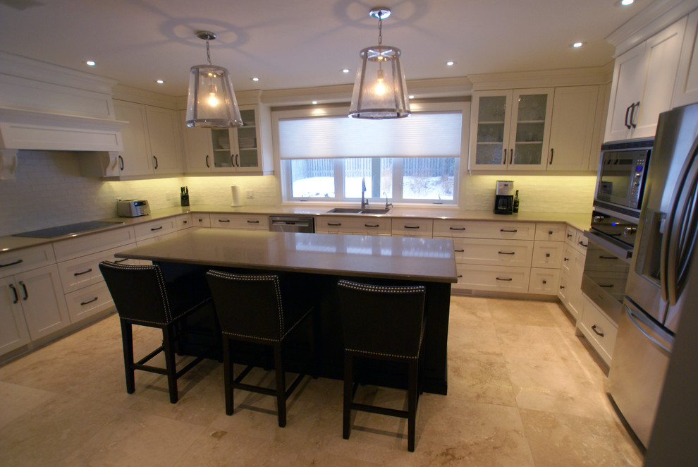 Inspiration for a large transitional u-shaped brown floor enclosed kitchen remodel with white cabinets, granite countertops, stainless steel appliances, an island, an undermount sink, white backsplash and shaker cabinets