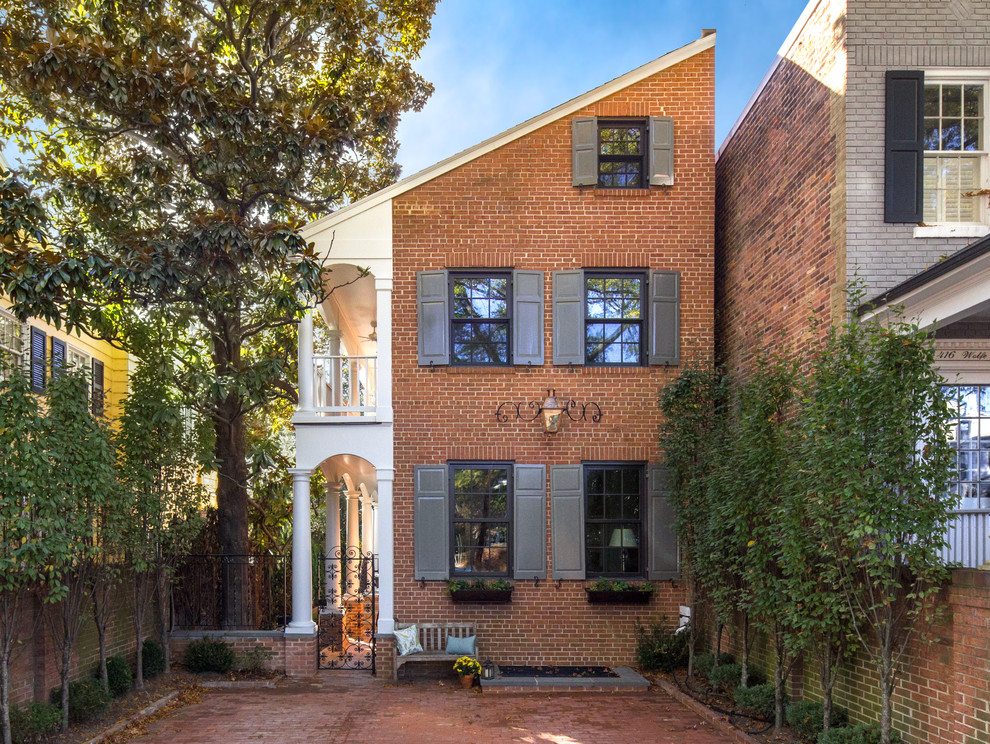 Traditional three-storey brick red townhouse exterior in DC Metro with a shed roof.