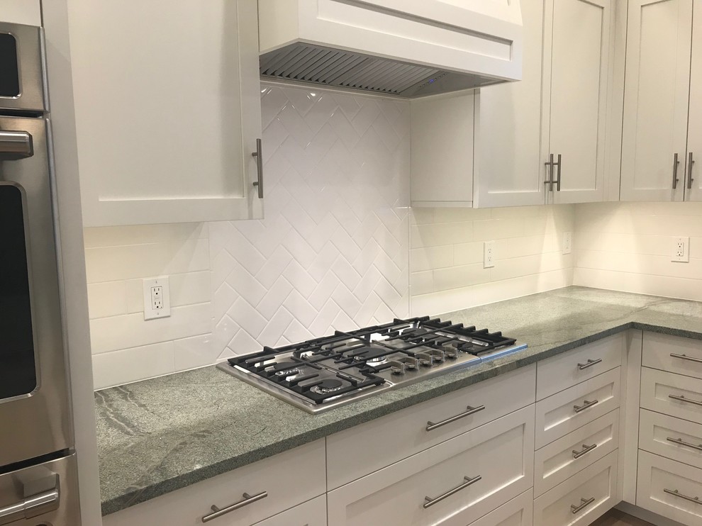 Inspiration for a transitional light wood floor eat-in kitchen remodel in Bridgeport with shaker cabinets, white cabinets, granite countertops, white backsplash, subway tile backsplash, stainless steel appliances, an island and green countertops