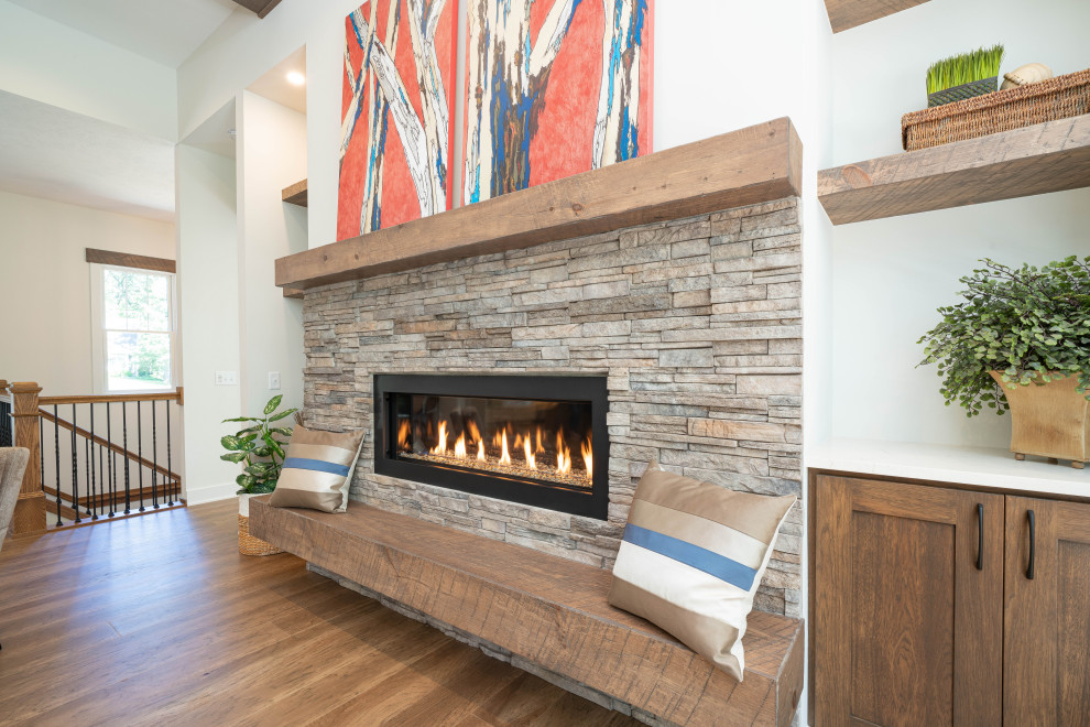 Design ideas for a large eclectic open concept family room in Grand Rapids with white walls, light hardwood floors, a standard fireplace, brown floor and exposed beam.