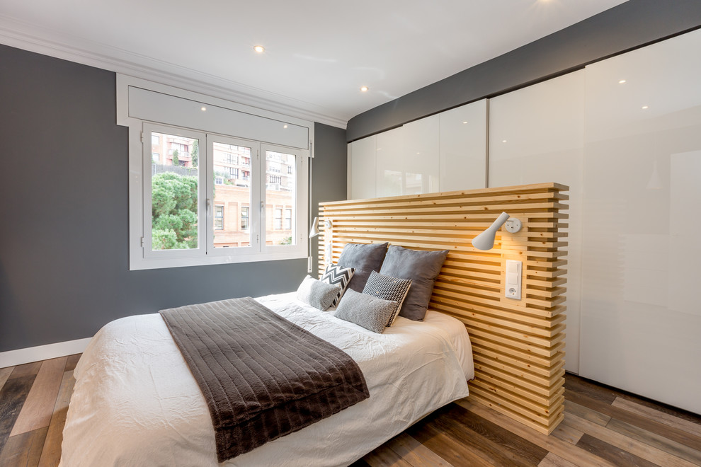 Mid-sized contemporary master bedroom in Other with grey walls and medium hardwood floors.