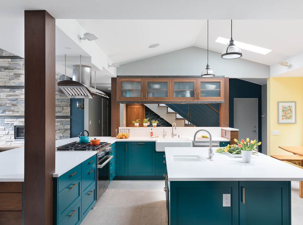 Inspiration for a transitional l-shaped eat-in kitchen in Seattle with a farmhouse sink, shaker cabinets, green cabinets, stainless steel appliances, with island, grey floor and white benchtop.