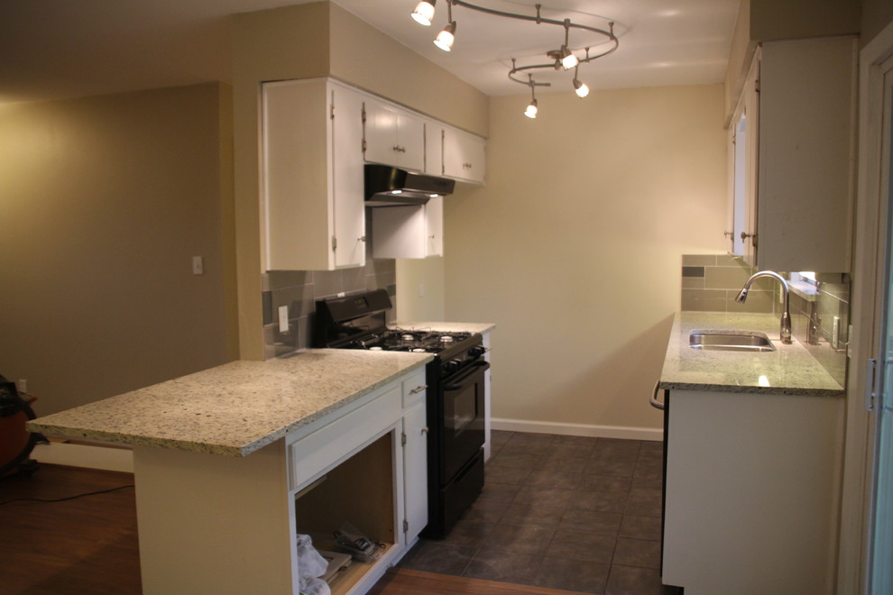 Small transitional u-shaped slate floor enclosed kitchen photo in Austin with an undermount sink, white cabinets, granite countertops, glass tile backsplash, stainless steel appliances, flat-panel cabinets, gray backsplash and no island