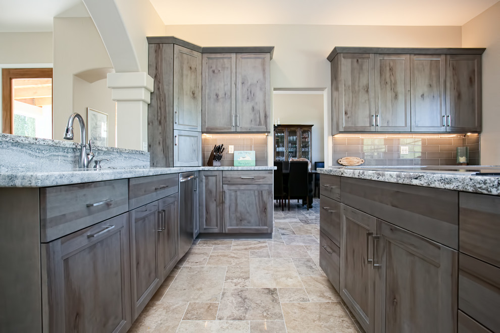Example of a small mountain style l-shaped ceramic tile eat-in kitchen design in Phoenix with an undermount sink, flat-panel cabinets, gray cabinets, granite countertops, gray backsplash, ceramic backsplash, stainless steel appliances and an island