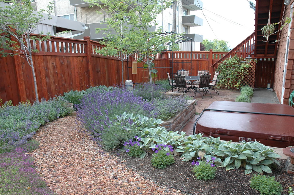 Inspiration for a small eclectic backyard full sun xeriscape for summer in Salt Lake City with a retaining wall and gravel.