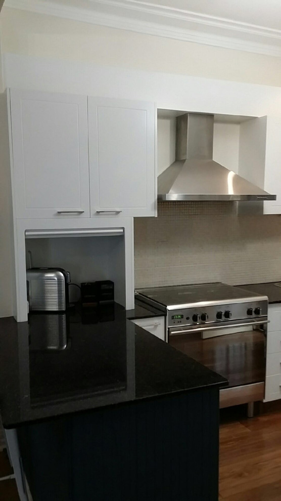 This is an example of a modern kitchen in Sydney with white cabinets.