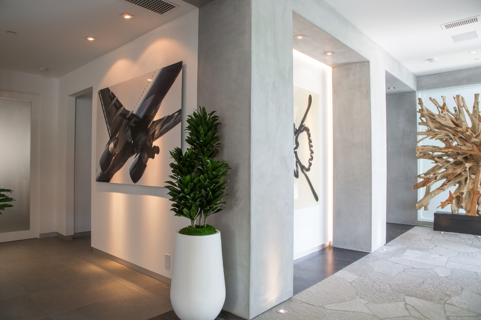 This is an example of a mid-sized contemporary hallway in Los Angeles with grey walls, limestone floors and grey floor.