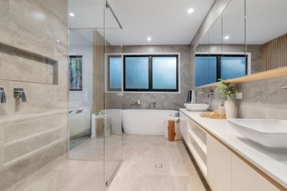 Cette photo montre une grande salle de bain principale tendance avec une baignoire indépendante, une douche à l'italienne, un sol en carrelage de céramique, un plan de toilette blanc, meuble double vasque et meuble-lavabo encastré.