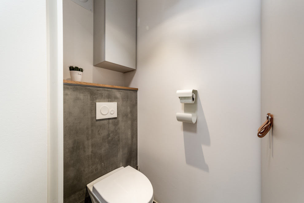 Inspiration for a small scandinavian cloakroom in Lyon with a wall mounted toilet, grey tiles, white walls, ceramic flooring, grey floors, a built in vanity unit, flat-panel cabinets, grey cabinets, ceramic tiles, wooden worktops and beige worktops.