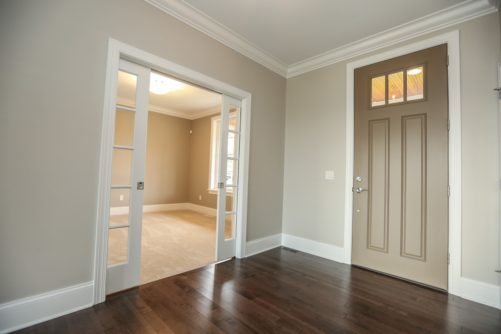 Inspiration for a mid-sized transitional foyer in New York with beige walls, medium hardwood floors, a single front door, a brown front door and brown floor.