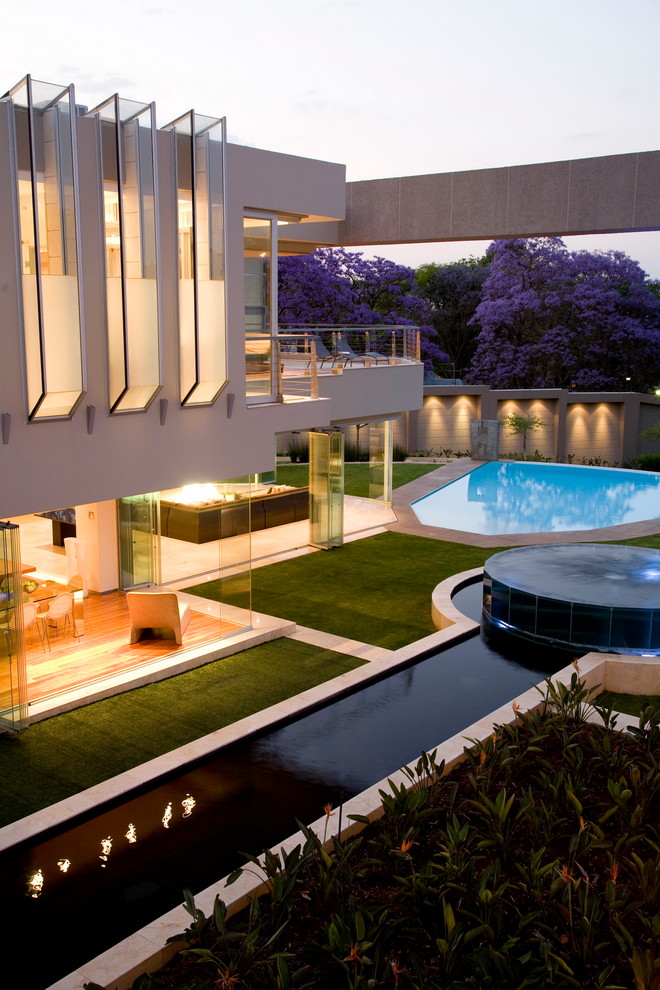 This is an example of a contemporary backyard garden in Other with a water feature.