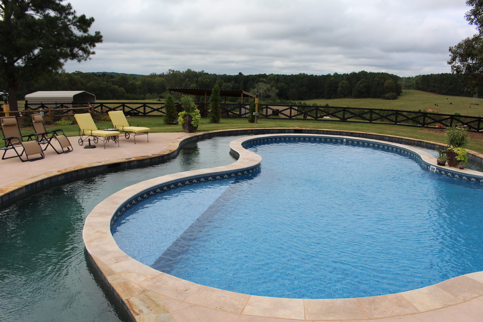 Photo of an expansive country backyard custom-shaped pool in Atlanta with a water feature.