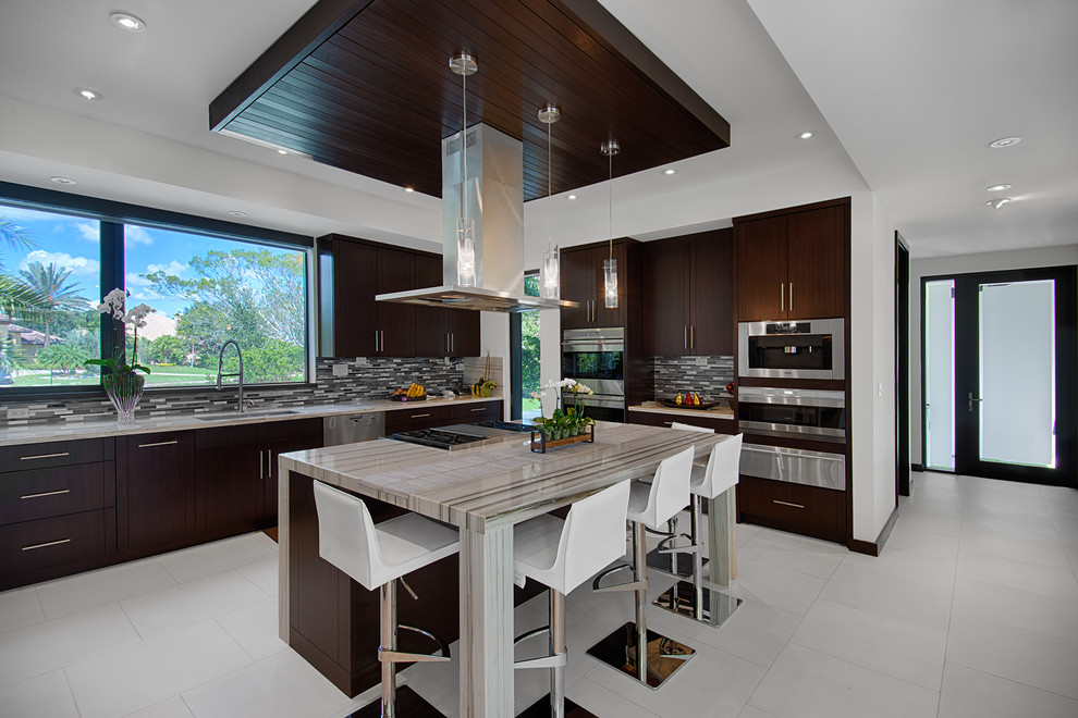 Design ideas for a contemporary u-shaped open plan kitchen in Miami with porcelain floors, with island, flat-panel cabinets, dark wood cabinets, multi-coloured splashback, stainless steel appliances and an undermount sink.