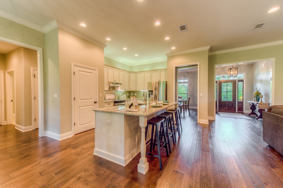 Inspiration for a mid-sized transitional l-shaped medium tone wood floor open concept kitchen remodel in Miami with shaker cabinets, white cabinets, granite countertops, beige backsplash, stainless steel appliances and an island