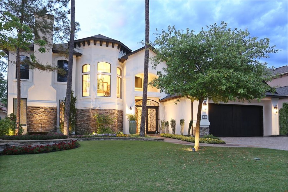 Photo of a large mediterranean two-storey beige house exterior in Houston with mixed siding, a gable roof and a shingle roof.