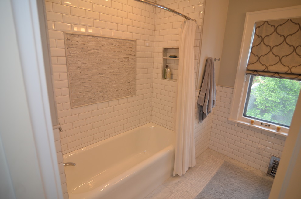 This is an example of a mid-sized transitional bathroom in Portland with an undermount sink, shaker cabinets, grey cabinets, marble benchtops, a shower/bathtub combo, a two-piece toilet, white tile, stone tile, grey walls and marble floors.