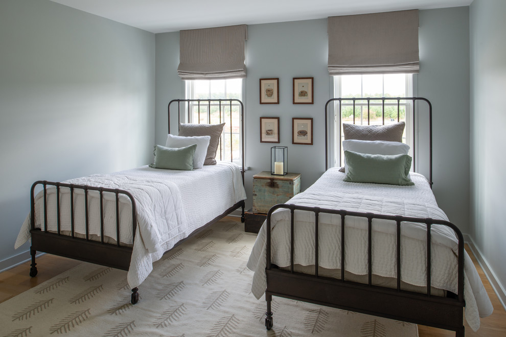 Inspiration for a mid-sized country guest bedroom in DC Metro with blue walls, medium hardwood floors and brown floor.