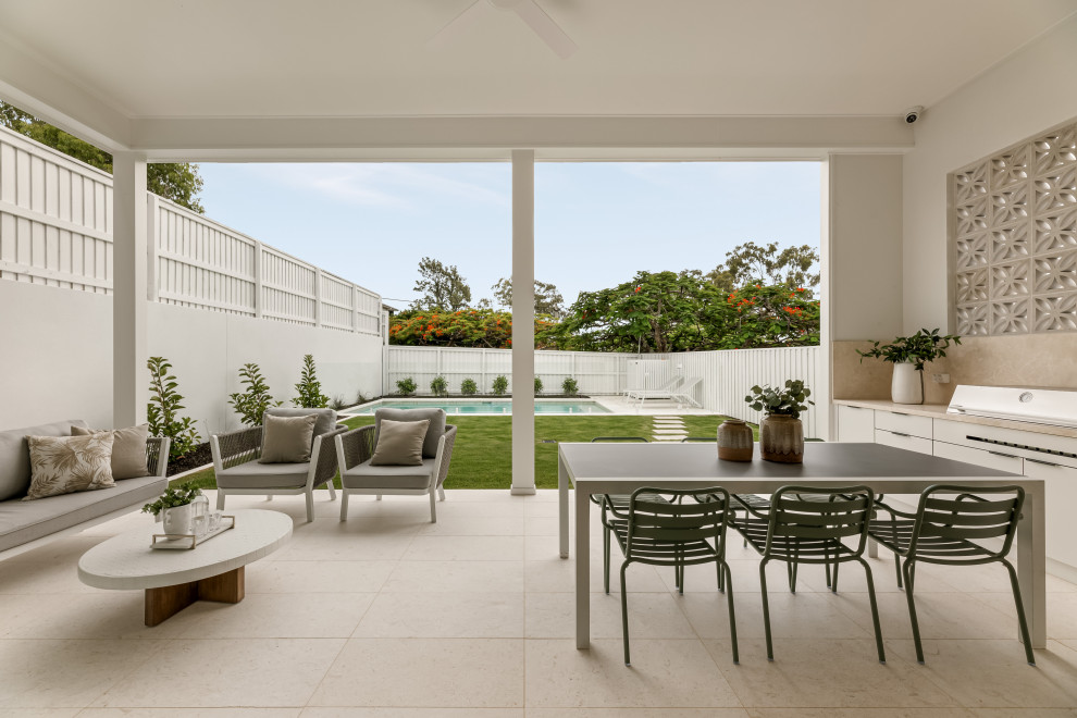 This is an example of a modern patio in Brisbane with tile and a roof extension.